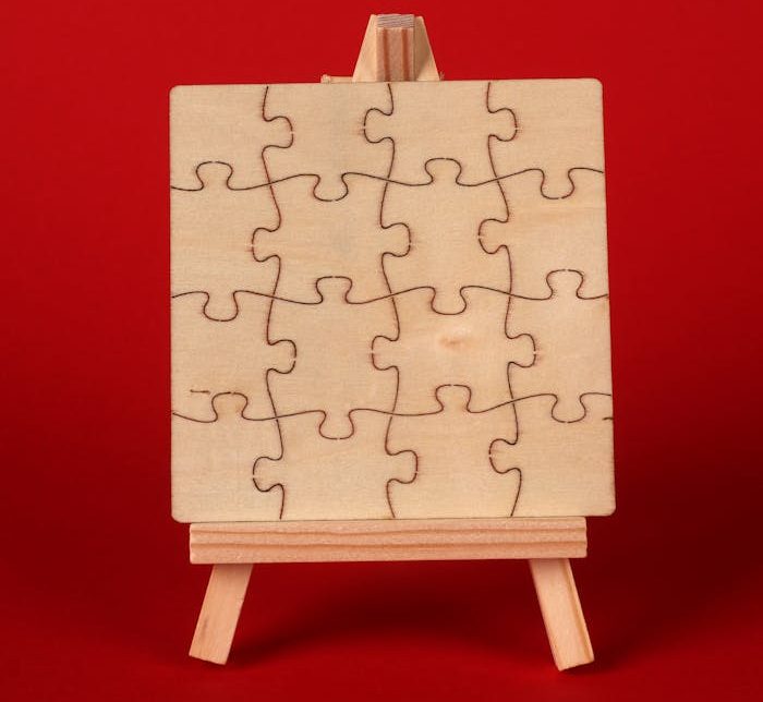 Minimalist wooden puzzle on easel with a vibrant red background, ideal for creativity concepts.